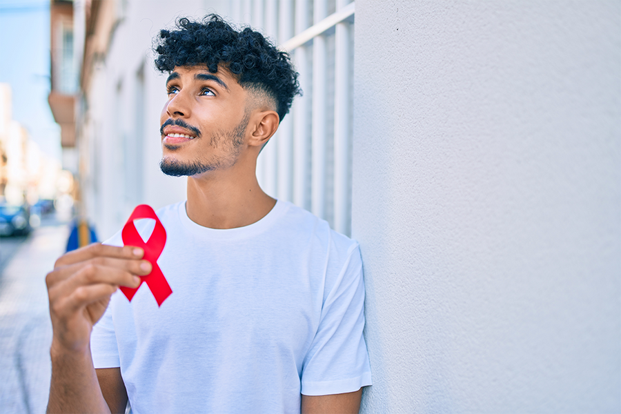 man gazing up holding a red ribbon